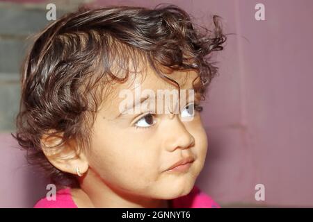 Close up face photo of an Indian resident of a little hindu child with a boy looking up Stock Photo