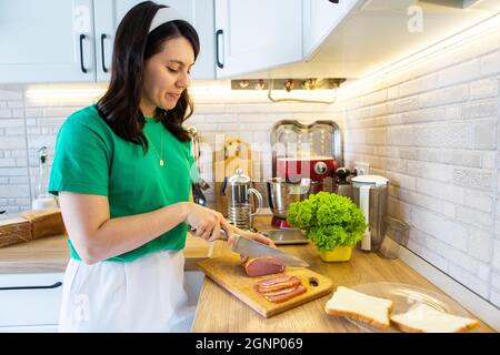 making sandwich slicing ham on cutting board Stock Photo