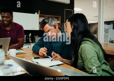Diverse group of business partners discussing important work before big meeting with boss  Stock Photo