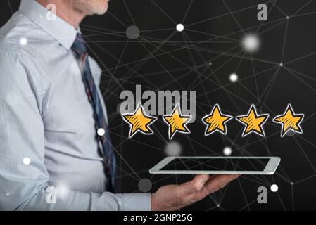 Quality concept above a tablet held by a man Stock Photo