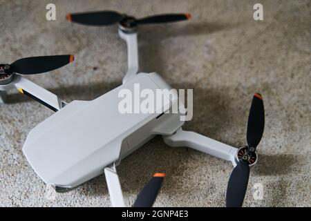Small gray quadcopter on a gray background. Quadrocopter close-up. Stock Photo