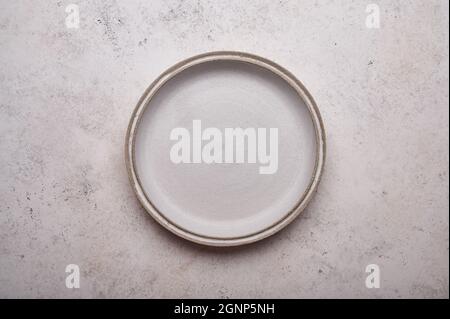 Empty ceramic plate on light concrete table background. Copy space. Menu recipe concept. Top view. Flat lay Stock Photo