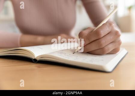 Close up of woman handwrite in notebook Stock Photo