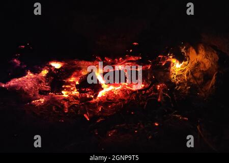 Close-up on the embers of a still glowing fire inside of a stone fireplace. Stock Photo