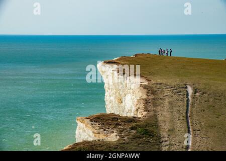 Walking on the top of the cliffs by Beachy Head lighthouse in East Sussex Stock Photo
