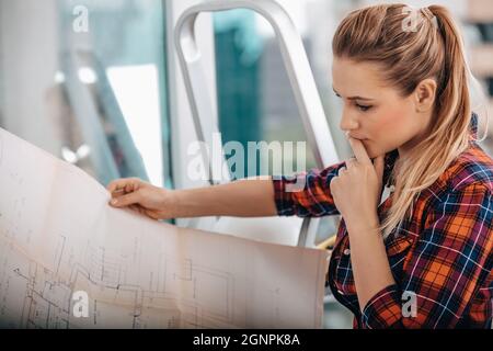 Portrait of a Serious Interior Architect. Woman Thinking about Apartment Design Plan. House Renovation. Stock Photo