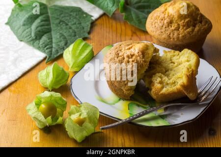 Gooseberry muffin on plate with gooseberries in foreground Stock Photo