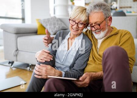 Retired happy senior couple spending time together with tablet. Technology people concept Stock Photo