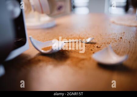 Close up of mug broken into pieces on the kitchen table Stock Photo