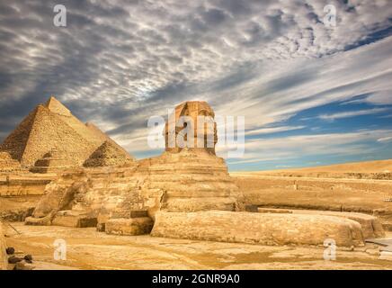 Clouds over Sphinx and pyramids in Cairo, Egypt Stock Photo