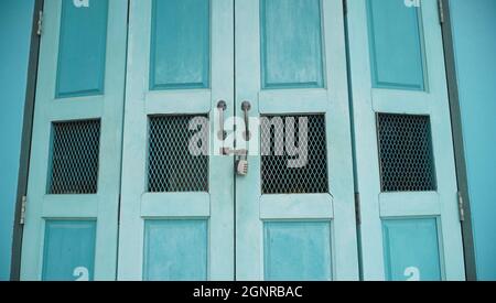 Blue vintage folding door with retro padlock and metal rusted handle Stock Photo