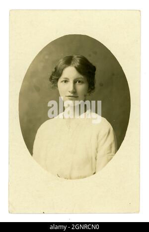 Original early 1900's oval portrait postcard of beautiful serene looking young lady by E.A. Osborne, Falmouth, Cornwall, England, U.K. circa 1913. Stock Photo