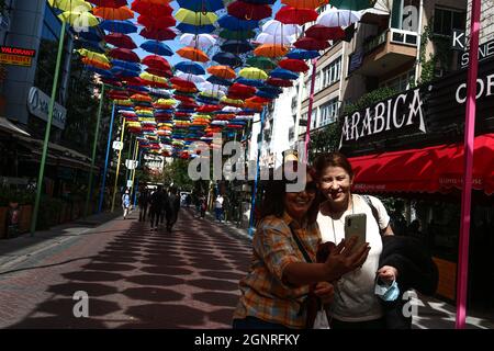 Ankara, Turkey. 27th Sep, 2021. A couple seen taking selfies under the umbrella using a mobile phone at Konur street.One of the busiest streets of Ankara, Konur street, umbrellas were hung by the municipality teams for decoration purposes. (Photo by Tunahan Turhan/SOPA Images/Sipa USA) Credit: Sipa USA/Alamy Live News Stock Photo