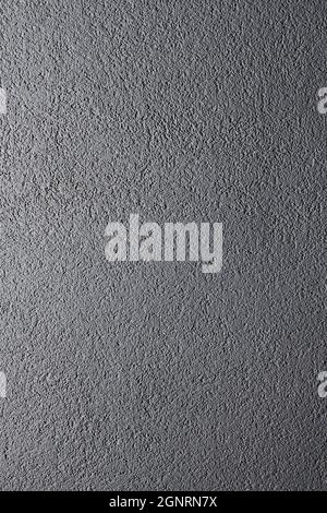 Grey matte stone wall texture. Uneven surface painted in gray colour. Backdrop with irregularities and relief. Vertical photo. Stock Photo