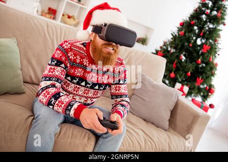 Photo portrait bearded man wearing 3d glasses watching virtual reality playing with joystick on couch Stock Photo