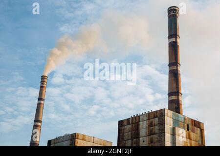 Air pollution, factory pipes, smoke from chimneys on sky background. Concept of industry, ecology, steam plant, heating season, global warming. Environmental Problem Stock Photo