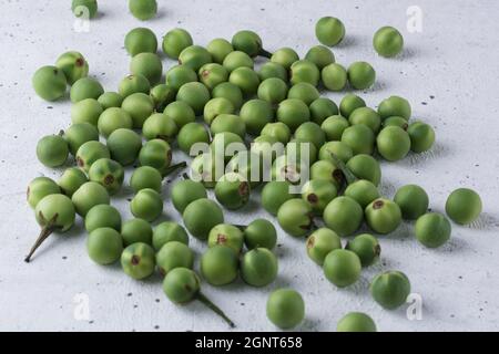 turkey berry, also called wild eggplant or pea eggplant, round vegetable on a textured white background Stock Photo