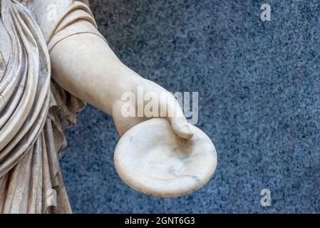 Close-up on hand of marble statue holding a round bread Stock Photo