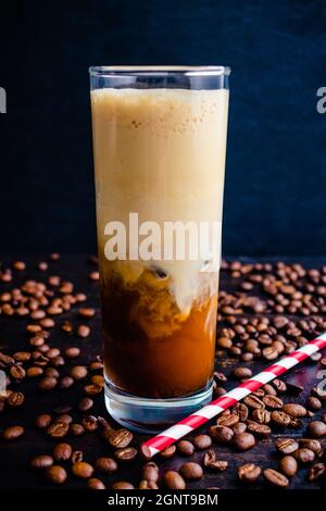 Iced Irish Coffee with Coffee Ice Cubes and Paper Straws: Tall glass of iced coffee made with Irish whiskey and coffee ice cubes Stock Photo
