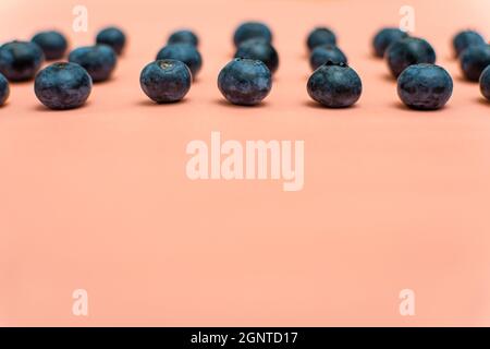 Scenic view of blueberries arranged in rows on an old pink background Stock Photo