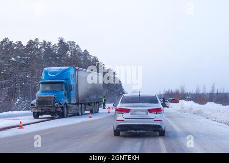 collision of a truck and a passenger car on a slippery winter road Stock Photo