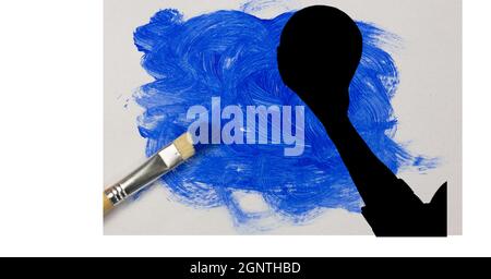 Mid section of silhouette of female handball player against blue paint stain and paint brush Stock Photo