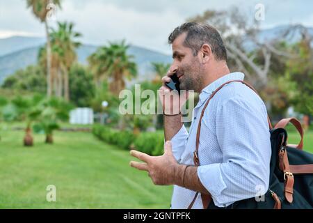 Mature business man talking on the phone outdoors Stock Photo