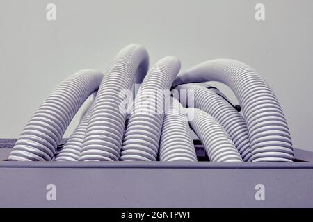 Electric cables and wires in white plastic corrugation, close up Stock Photo