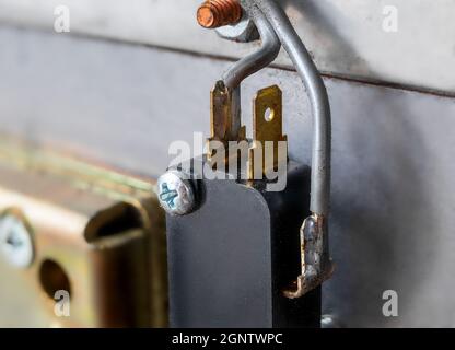 Wires attached to device, close up. Grey thick wires connected to prongs. Electronic or electricity background texture. Selective focus. Stock Photo