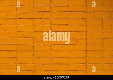matte orange painted brick wall full frame flat background and texture Stock Photo