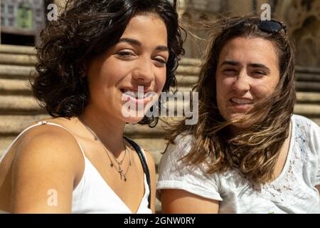 detail of a selfie photograph taken by two young Caucasian women smiling at the camera while sitting on the stairs Stock Photo