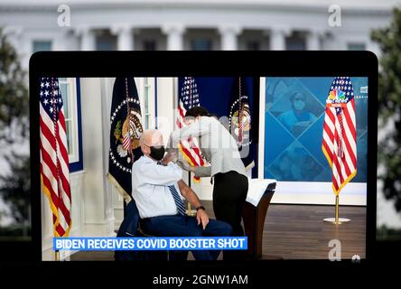 Washington, USA. 27th Sep, 2021. U.S. President Joe Biden is seen on a screen as he receives his COVID-19 vaccine booster shot in Washington, DC, the United States, on Sept. 27, 2021. Biden on Monday received his COVID-19 vaccine booster shot on camera at the White House. Credit: Liu Jie/Xinhua/Alamy Live News