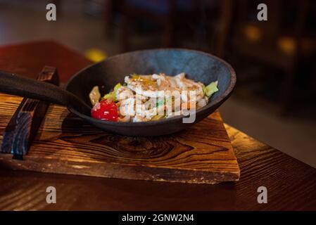 Stir fried garlic chicken in a luxury pan in a restaurant Stock Photo