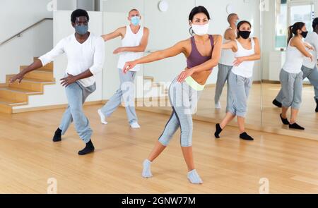 Group of people in protective masks practicing active dancing Stock Photo