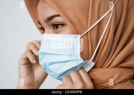 Coronavirus. Asian woman putting on a medical disposable mask to avoid viruses. Stock Photo