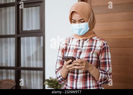 Coronavirus. Asian woman putting on a medical disposable mask to avoid viruses. Stock Photo
