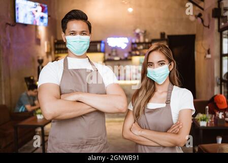 Waitress wearing a face mask at the coffee shop Stock Photo