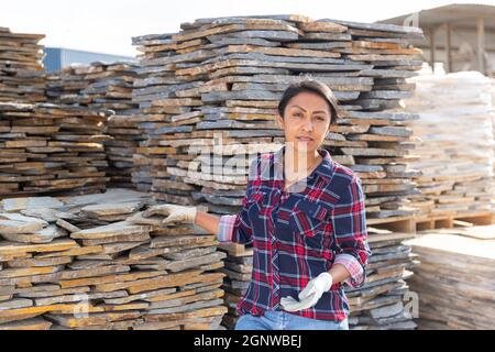 Hispanic woman worker posing with natural stone tile Stock Photo