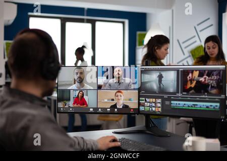 Senior video editor director talking with creative team in web online meeting on video call editing client footage work. Man getting feedback on movie using post production software on pc Stock Photo