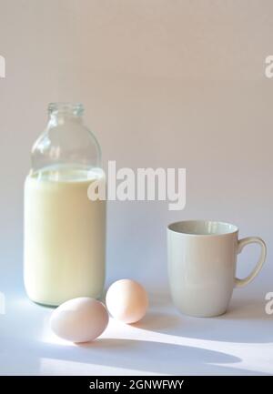 Bottle with milk, coffee cup and eggs on white background Stock Photo