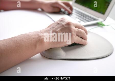 Man's fingers clicking on mouse, resting his wrist on wrist rest.  Close up shot. Stock Photo
