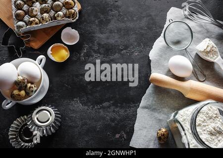 ingredients for baking, flour, eggs, forms and utensils on a black background with place for text Stock Photo