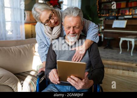 Senior couple having fun and laughing while using their tablet pc computer. Stock Photo