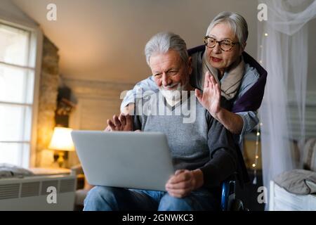 Happy senior couple using notebook at home and having fun together. Technology people concept Stock Photo