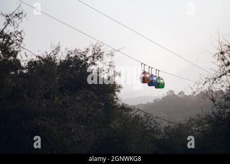 Three trolleys on a ropeway carrying tourists to Karni Mata temple in Udaipur, Rajasthan Stock Photo