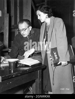Director FRITZ LANG and Continuity Girl DOROTHY HUGHES on set candid checking script during filming of SECRET BEYOND THE DOOR 1947 director FRITZ LANG story Rufus King screenplay Silvia Richards music Miklos Rozsa gowns Travis Banton  Walter Wanger Productions (as a Diana Production) / Universal Pictures Stock Photo
