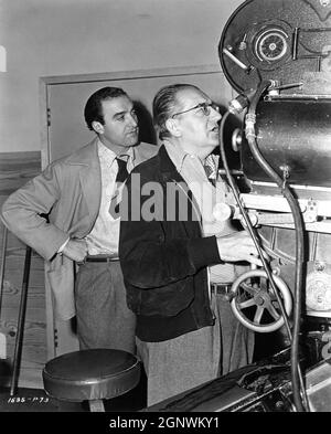 Cinematographer STANLEY CORTEZ and Director FRITZ LANG on set candid during filming of SECRET BEYOND THE DOOR 1947 director FRITZ LANG story Rufus King screenplay Silvia Richards music Miklos Rozsa gowns Travis Banton  Walter Wanger Productions (as a Diana Production) / Universal Pictures Stock Photo