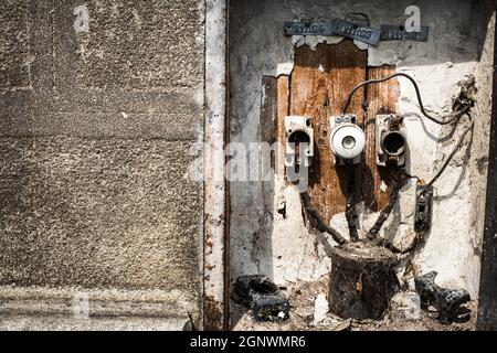 Old electrical cabinet with safety fuses, switches and wires. Stock Photo