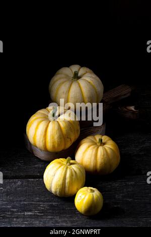 small yellow pumpkins on dark wooden background. Stock Photo
