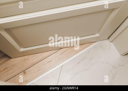 aluminum threshold between ceramic tiles and parquet Stock Photo